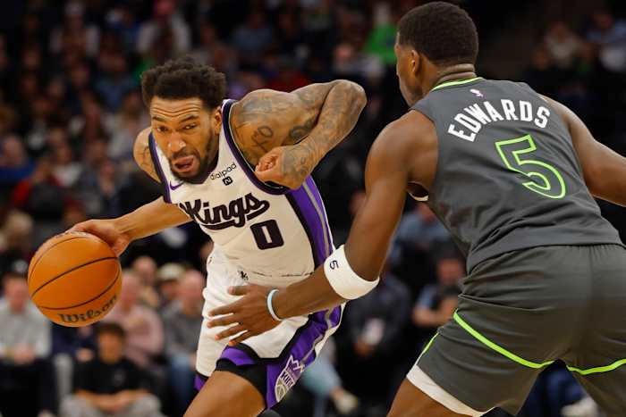 Mar 1, 2024; Minneapolis, Minnesota, USA; Sacramento Kings guard Malik Monk (0) works around Minnesota Timberwolves guard Anthony Edwards (5) in the first quarter at Target Center.